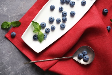 Photo of Flat lay composition with fresh blueberries on color table