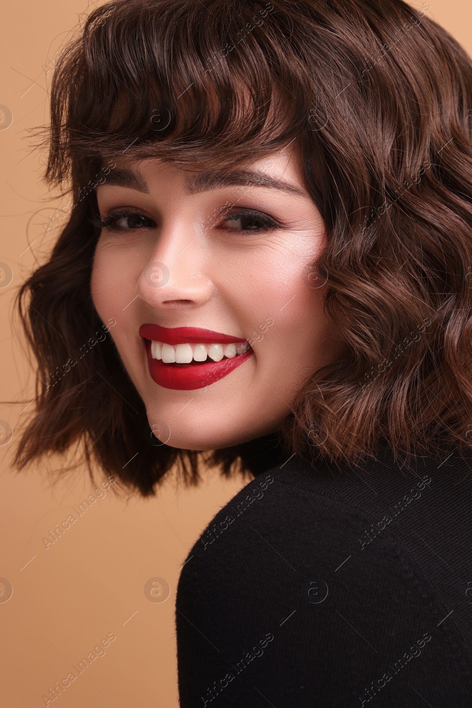 Photo of Beautiful young woman with wavy hairstyle on beige background