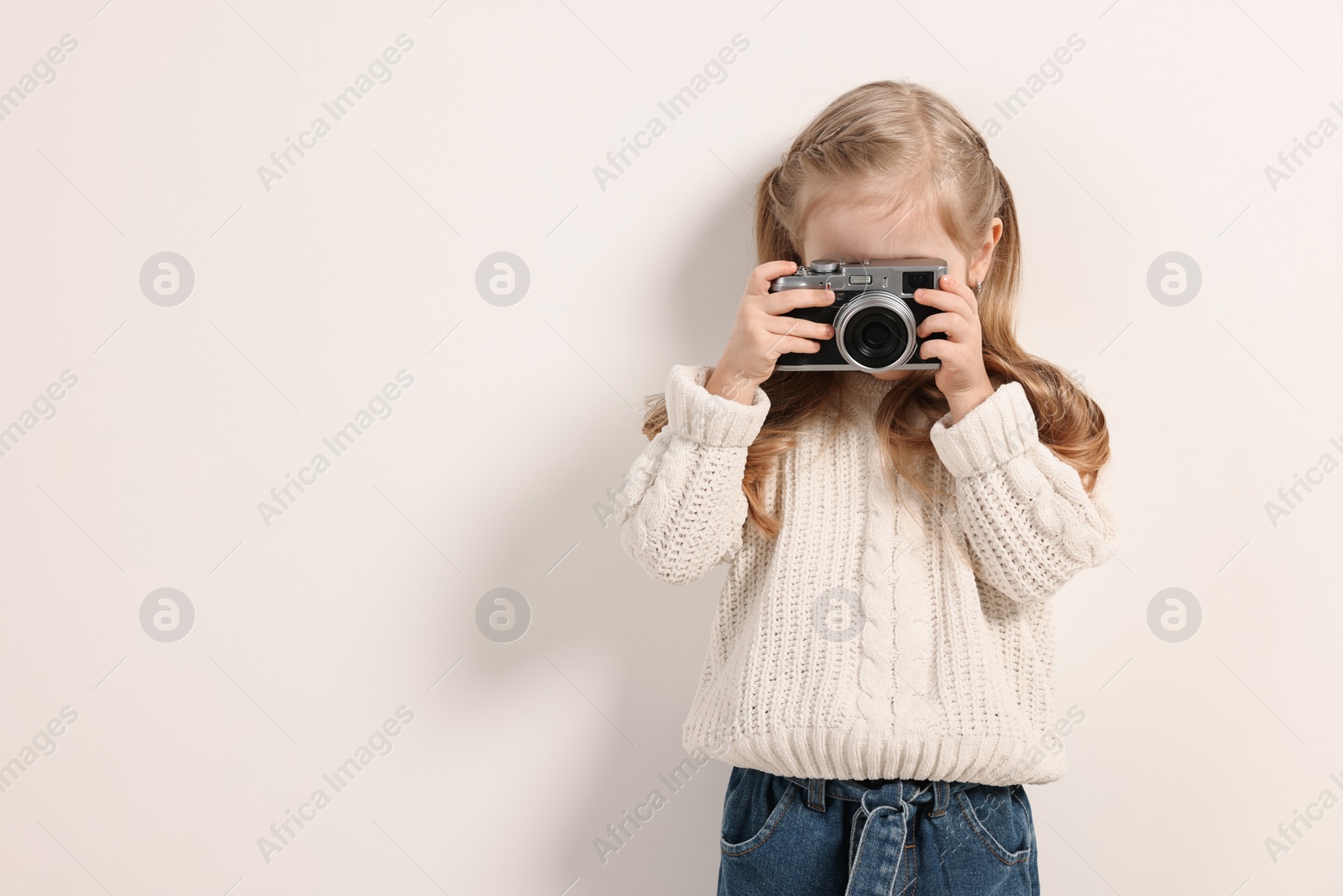 Photo of Fashion concept. Stylish girl with vintage camera on white background