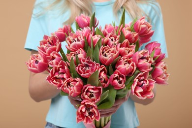 Photo of Woman with beautiful bouquet on beige background, closeup