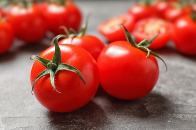 Photo of Fresh cherry tomatoes on stone background, closeup