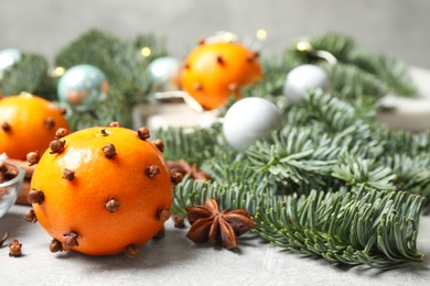 Delicious fresh tangerines with cloves on light table. Christmas celebration