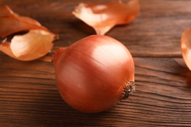 Fresh ripe onion on wooden table, closeup