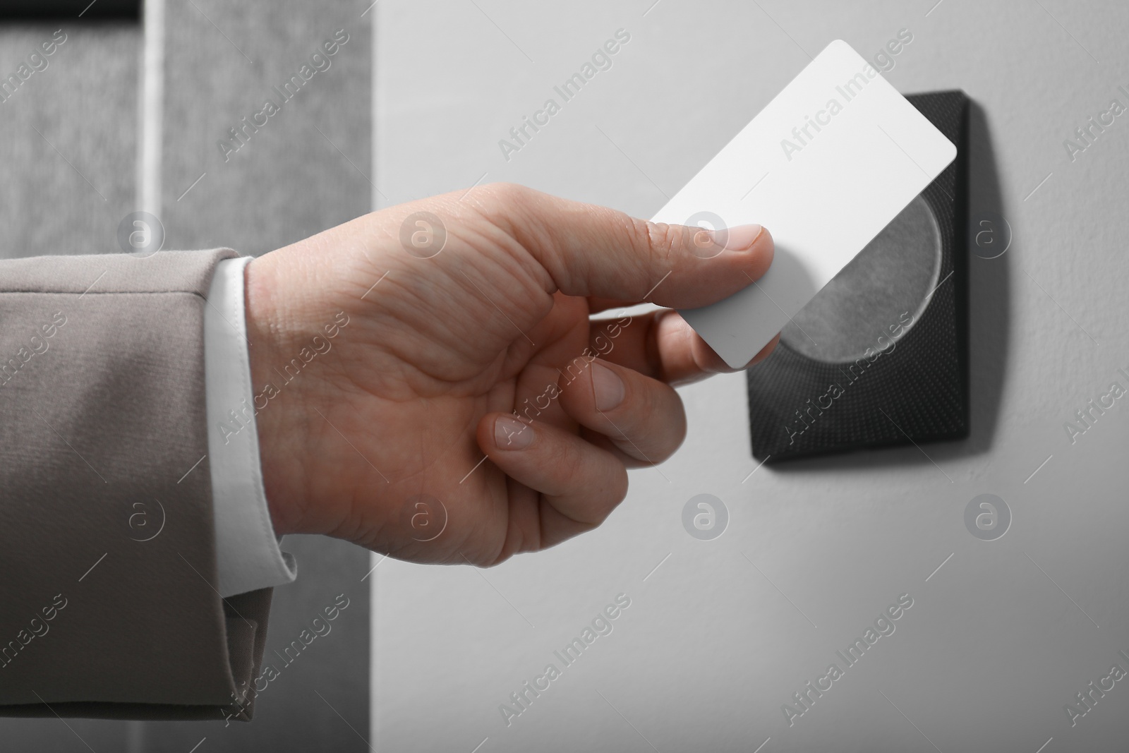 Photo of Man opening magnetic door lock with key card, closeup. Home security