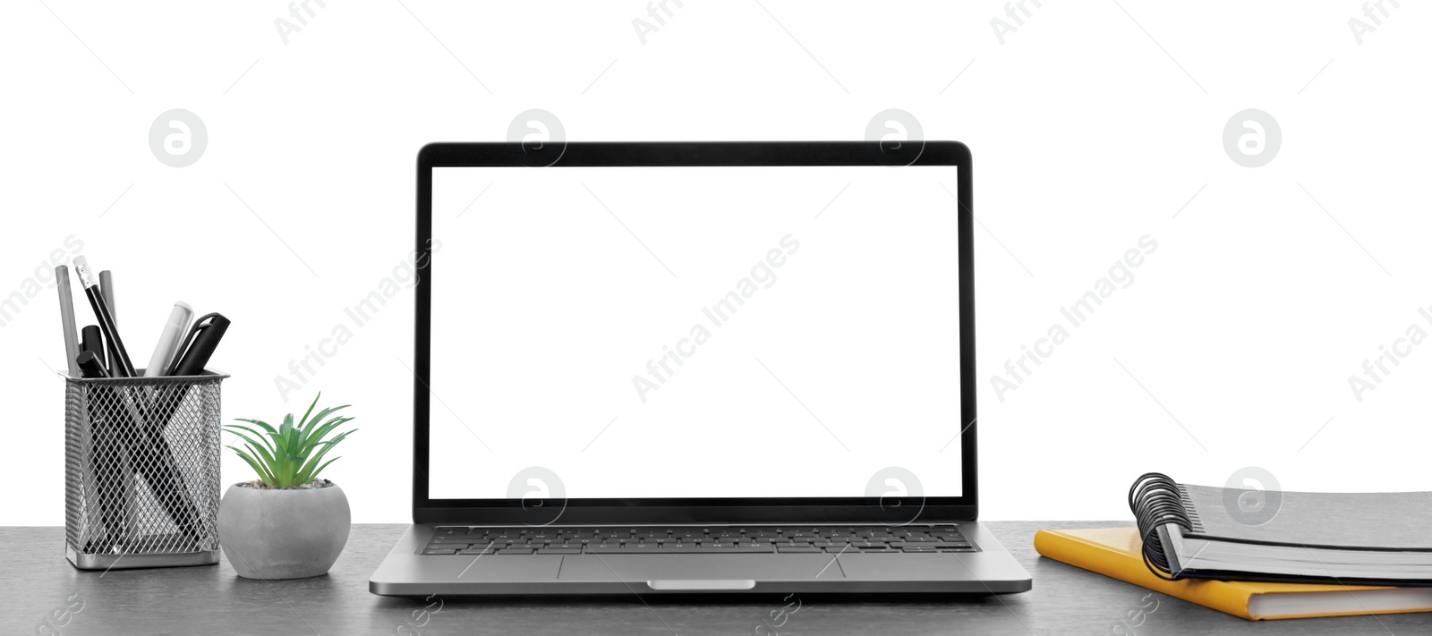 Photo of Computer, potted plant and stationery on table against white background. Stylish workplace