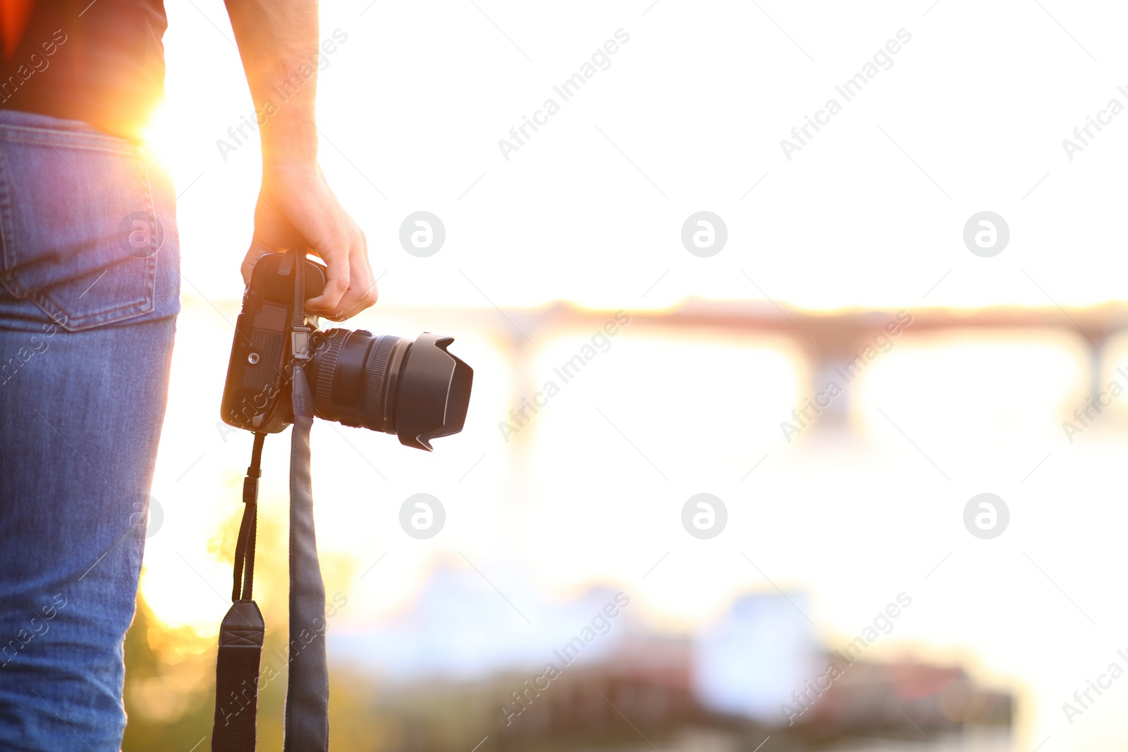 Photo of Photographer with professional camera outdoors on sunny day, closeup