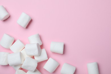Delicious puffy marshmallows on pink background, flat lay. Space for text