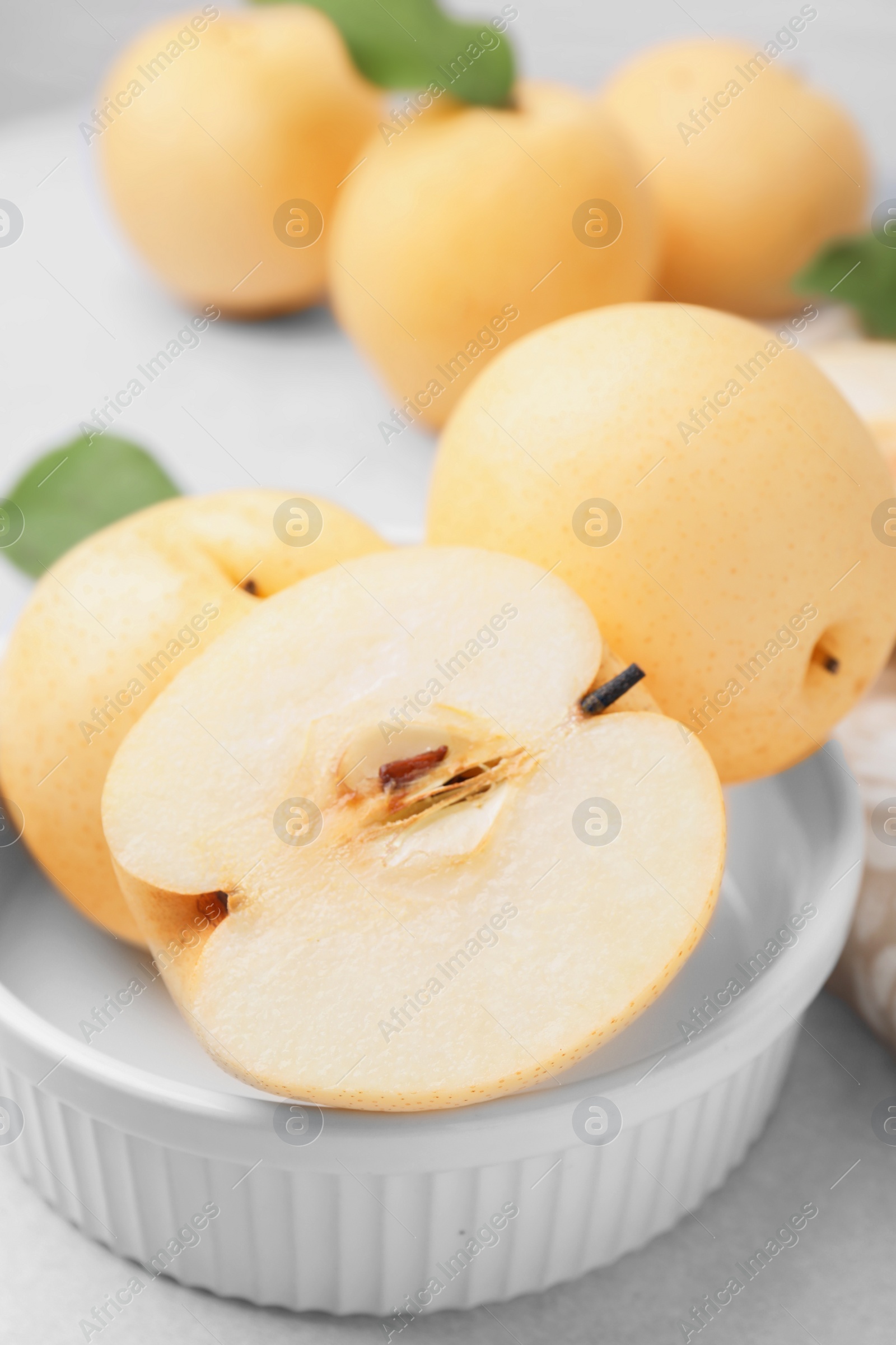 Photo of Bowl with delicious apple pears on white table, closeup