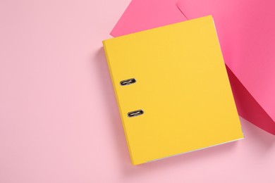 Photo of Yellow office folder on pink background, top view. Space for text