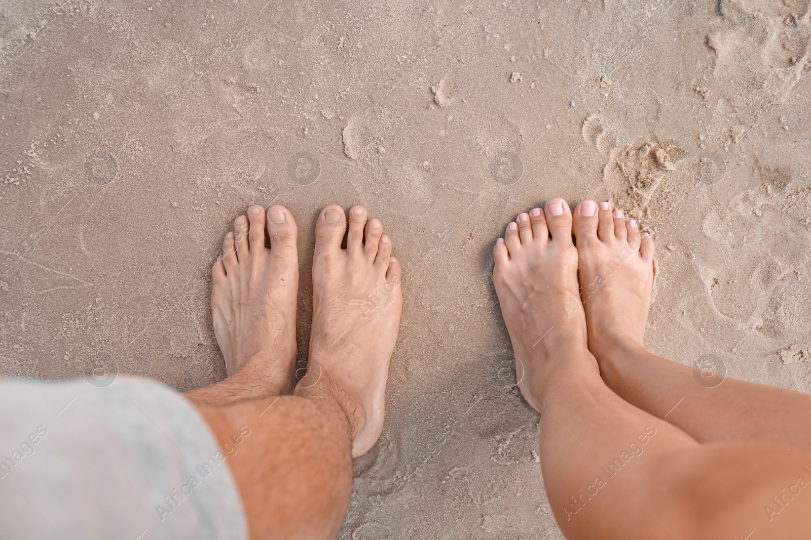 Photo of Happy young couple at beach on sunny day, closeup of feet