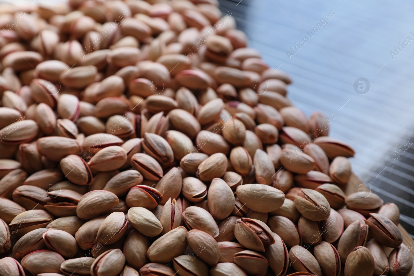 Photo of Many tasty pistachios on table, closeup view