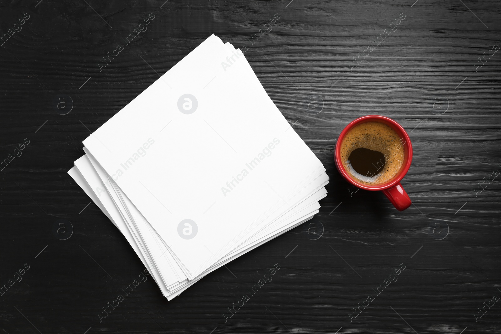 Photo of Blank paper sheets for brochure and cup of coffee on black wooden background, flat lay. Mock up