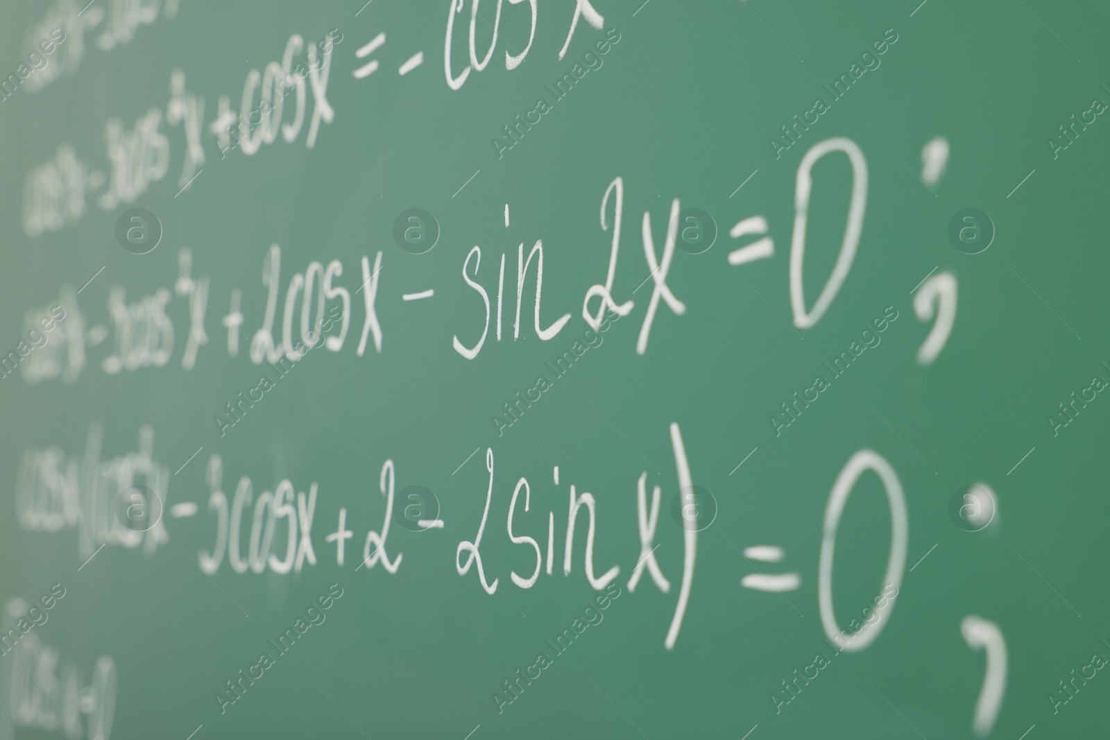 Photo of Many different math formulas written on green chalkboard, closeup