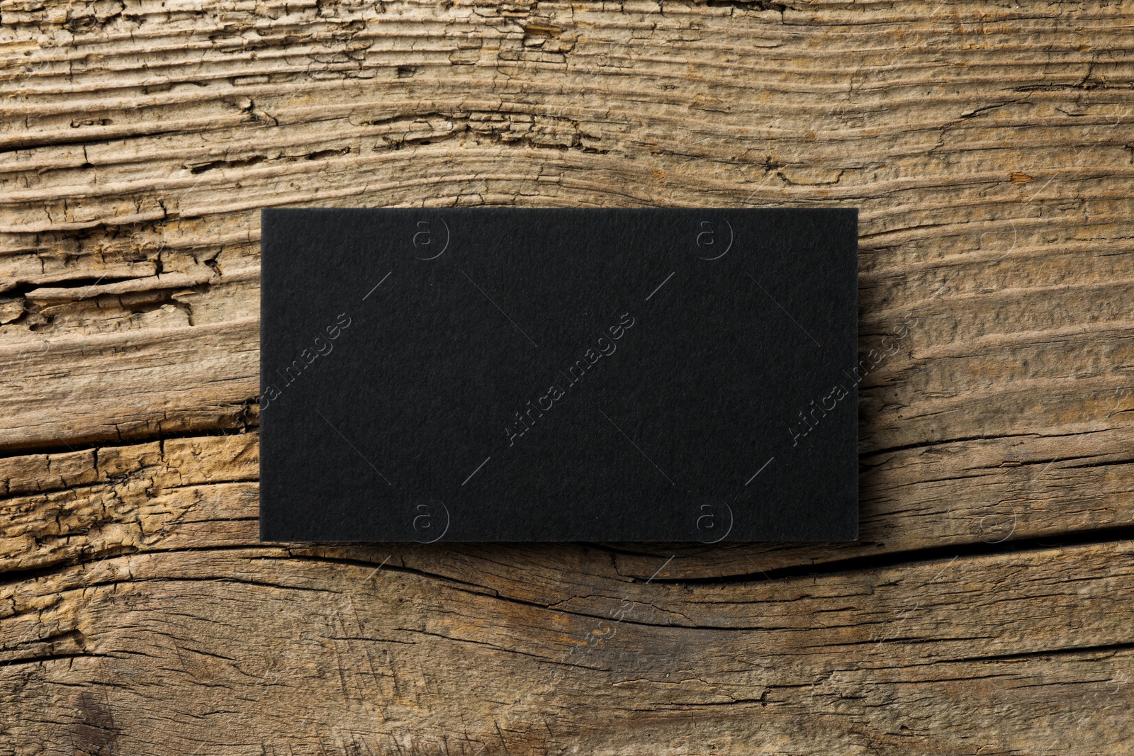 Photo of Empty black business card on wooden background, top view. Mockup for design