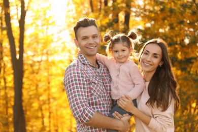 Photo of Happy family with little daughter in park. Autumn walk