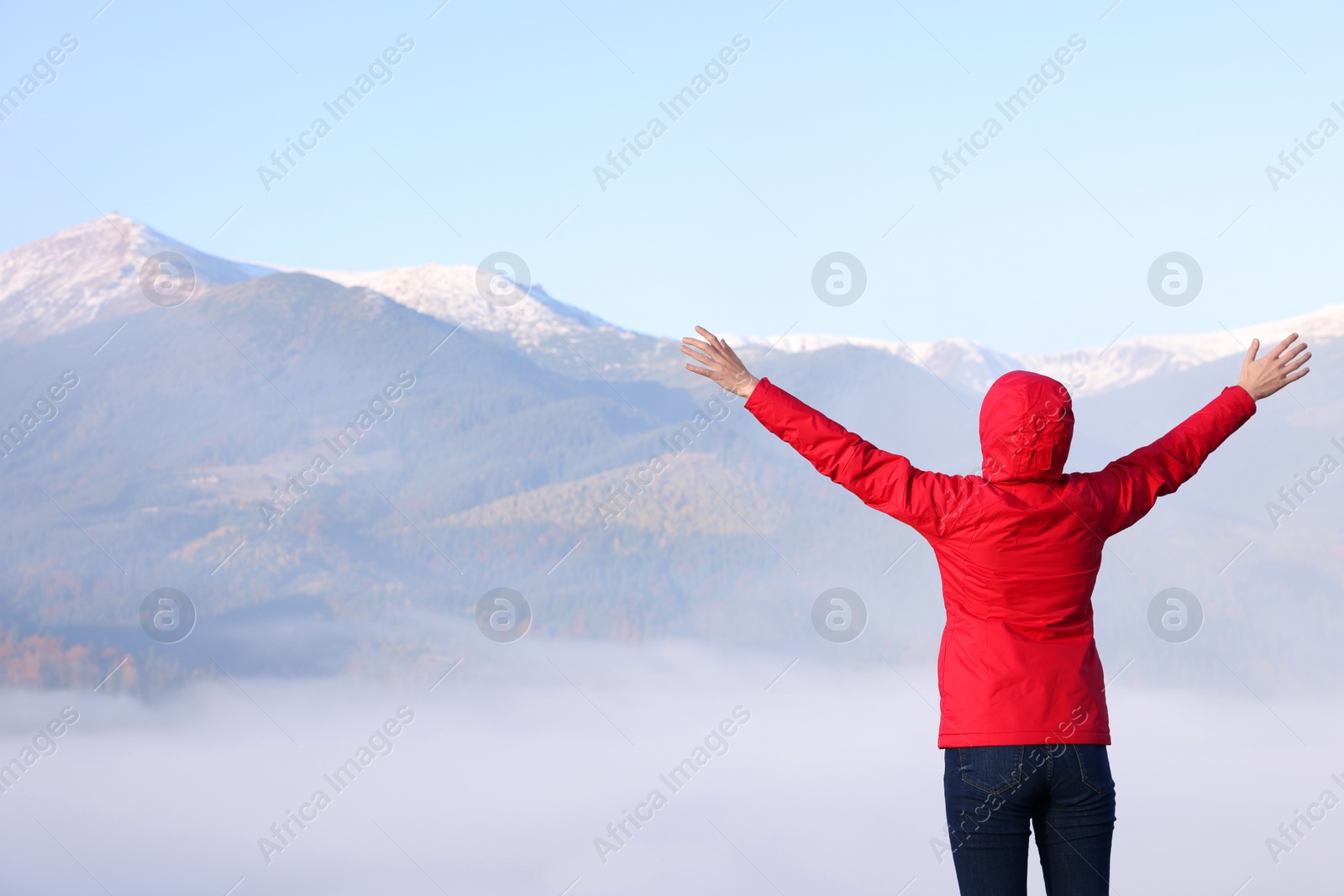 Photo of Woman admiring mountain landscape, back view. Freedom concept