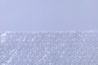 Photo of Transparent bubble wrap on gray background, top view. Space for text