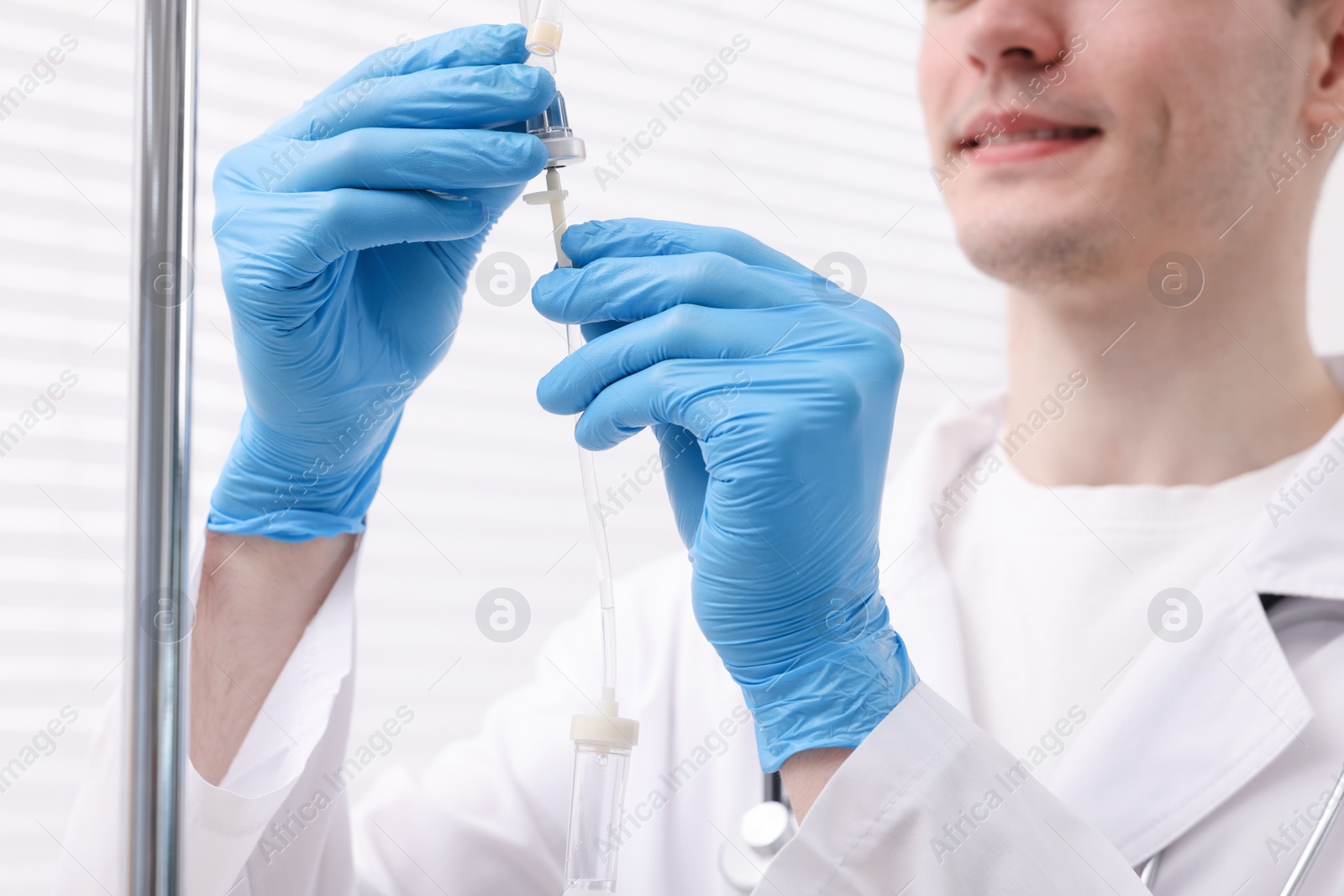 Photo of Doctor setting up IV drip in hospital, closeup