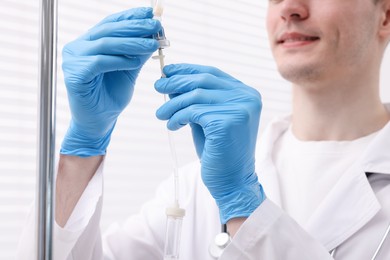 Photo of Doctor setting up IV drip in hospital, closeup