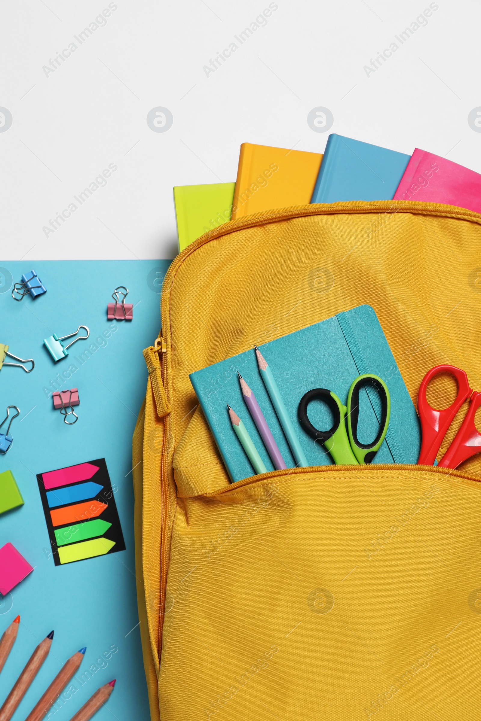 Photo of Backpack with different school stationery on color background, flat lay