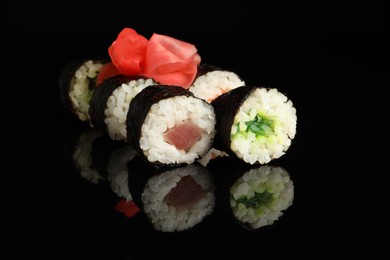 Set of delicious sushi rolls on black background, closeup