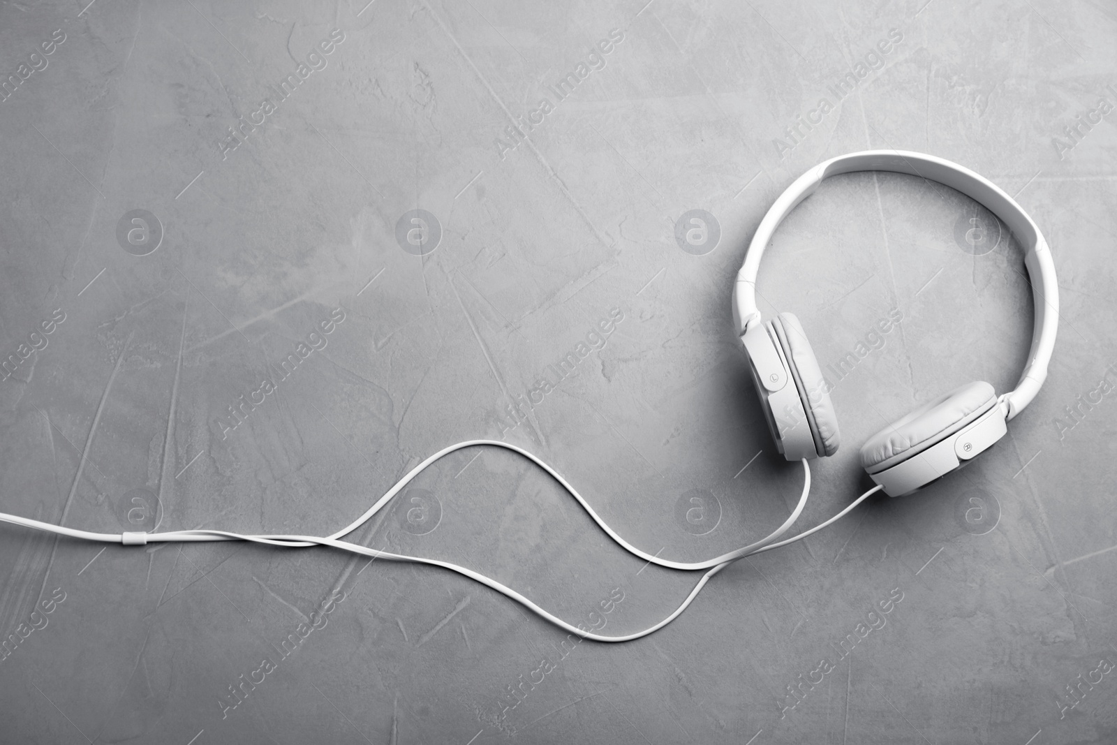 Photo of Stylish modern headphones and space for text on gray background, top view