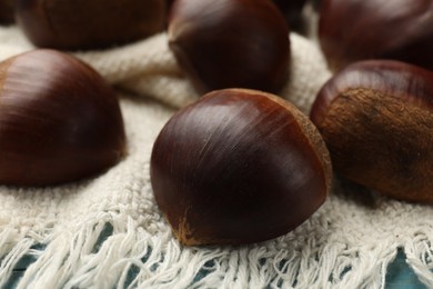 Photo of Roasted edible sweet chestnuts on table, closeup