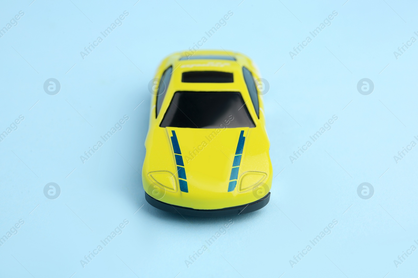 Photo of One yellow car on light blue background. Children`s toy