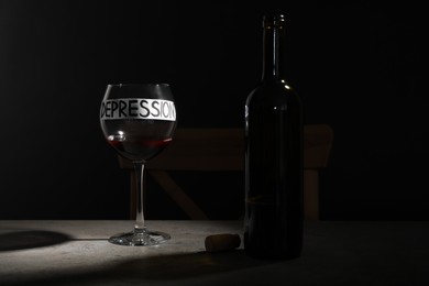 Photo of Composition with wine and word Depression on table in darkness