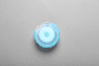 Container with dental floss on grey background, top view