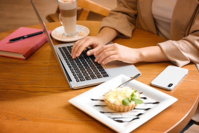 Photo of Blogger working with laptop in cafe, closeup