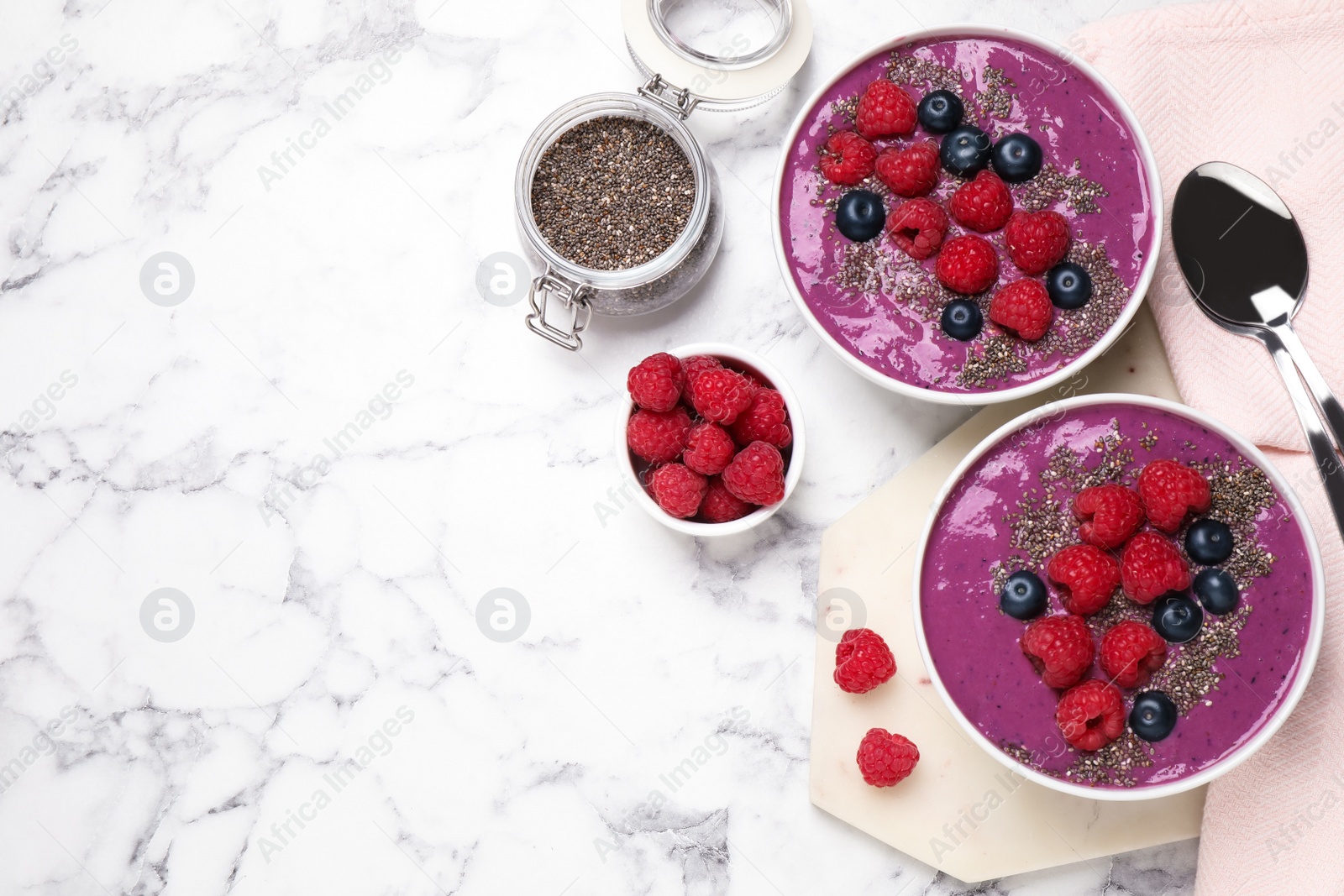 Photo of Delicious acai smoothie with fruits served on white marble table, flat lay. Space for text