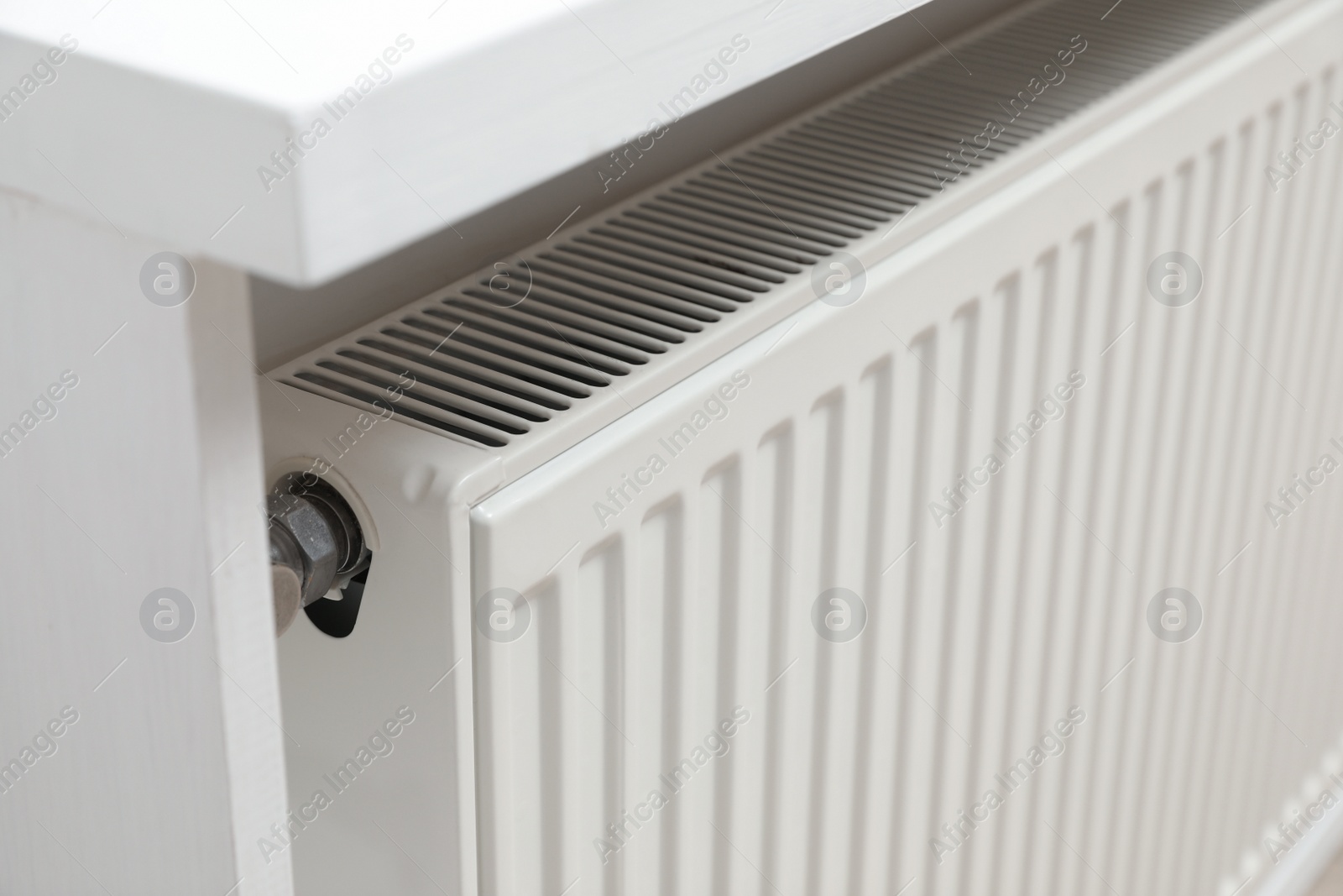 Photo of Closeup view of modern radiator. Central heating system