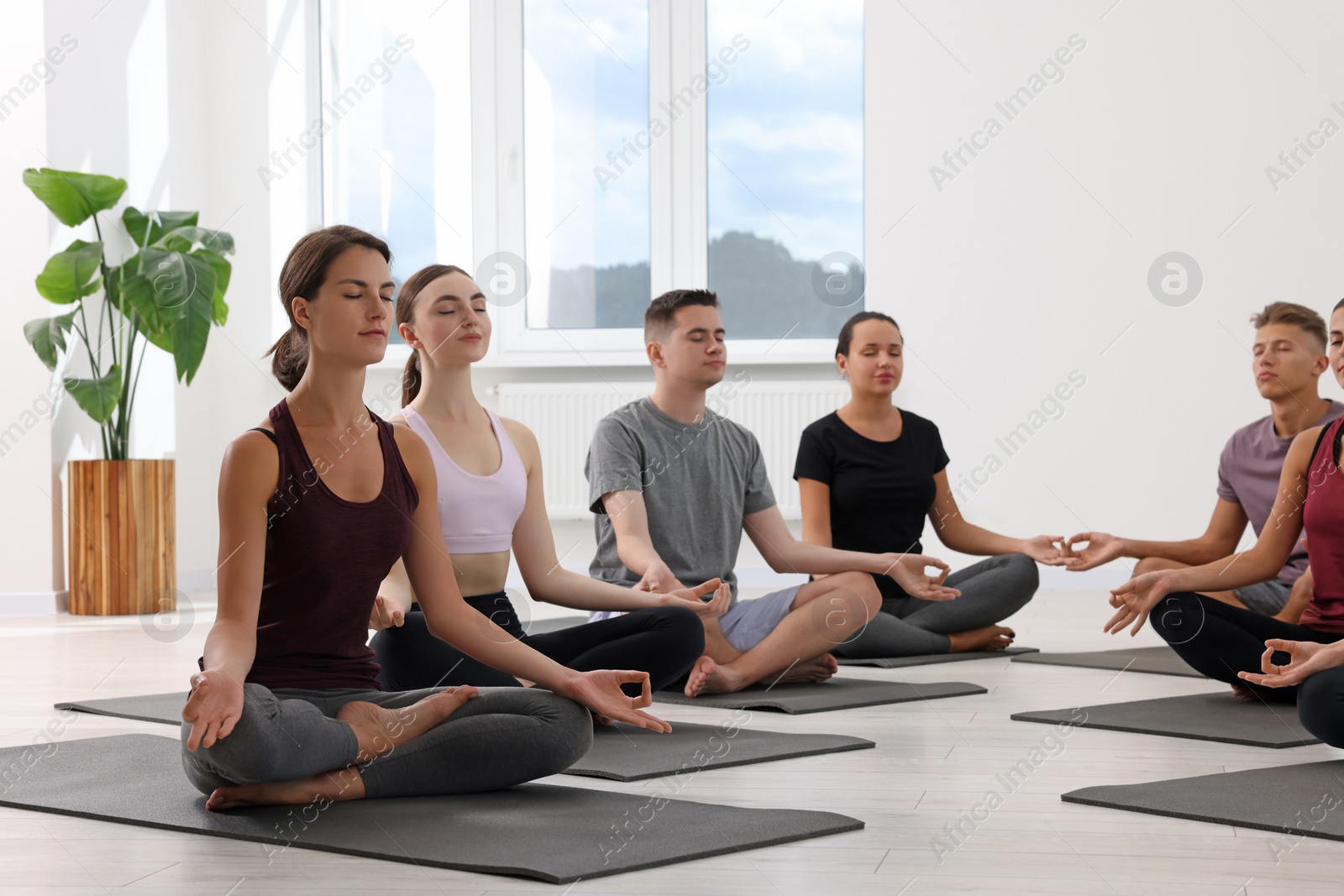 Photo of Group of people practicing yoga on mats indoors