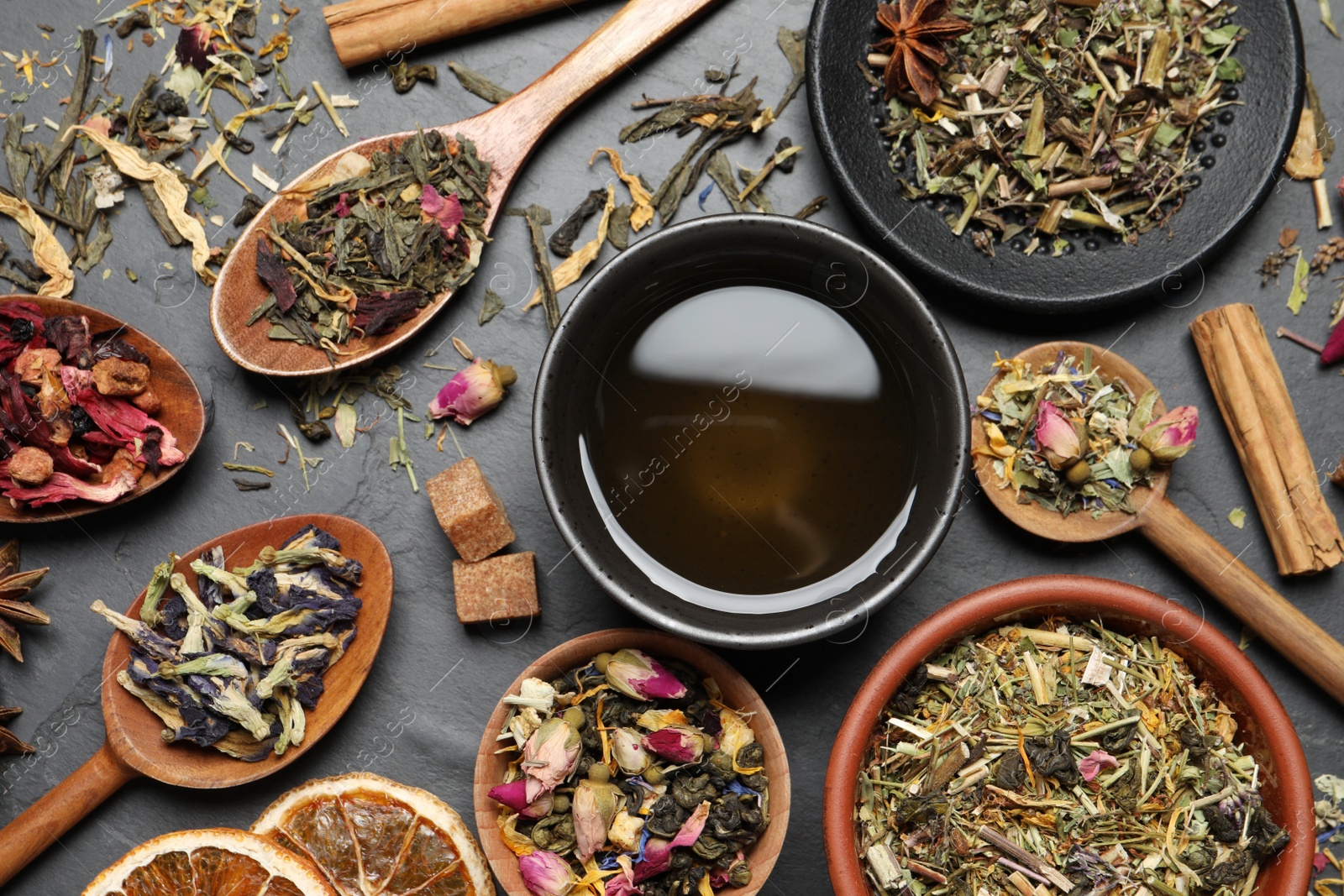 Photo of Flat lay composition with fresh brewed tea and dry leaves on grey table