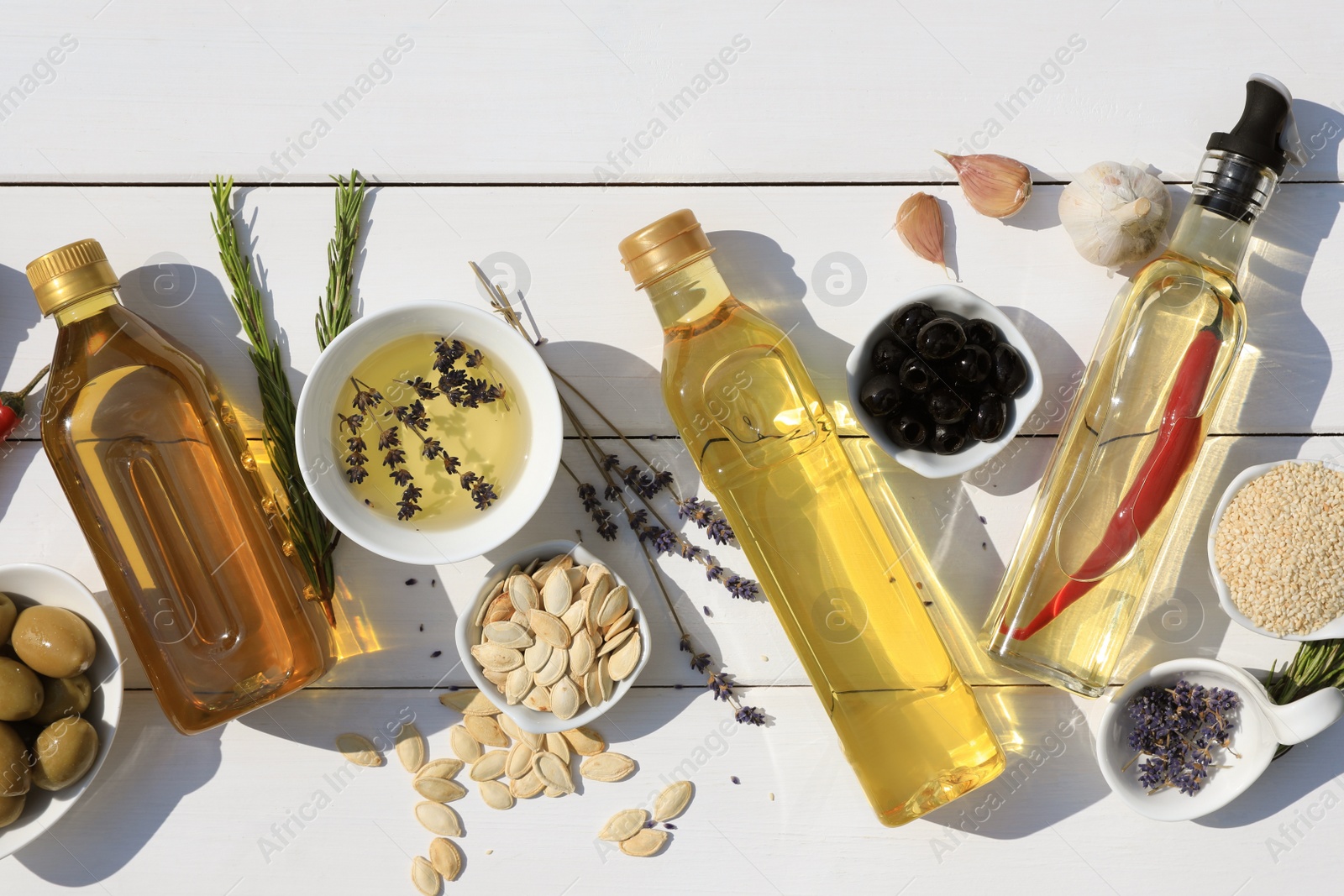 Photo of Flat lay composition with different cooking oils and ingredients on white wooden table