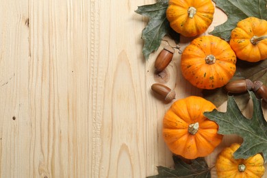 Thanksgiving day. Flat lay composition with pumpkins on light wooden table, space for text