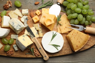 Photo of Flat lay composition with different sorts of cheese and knives on wooden table