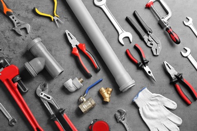 Photo of Flat lay composition with plumber's tools on grey background