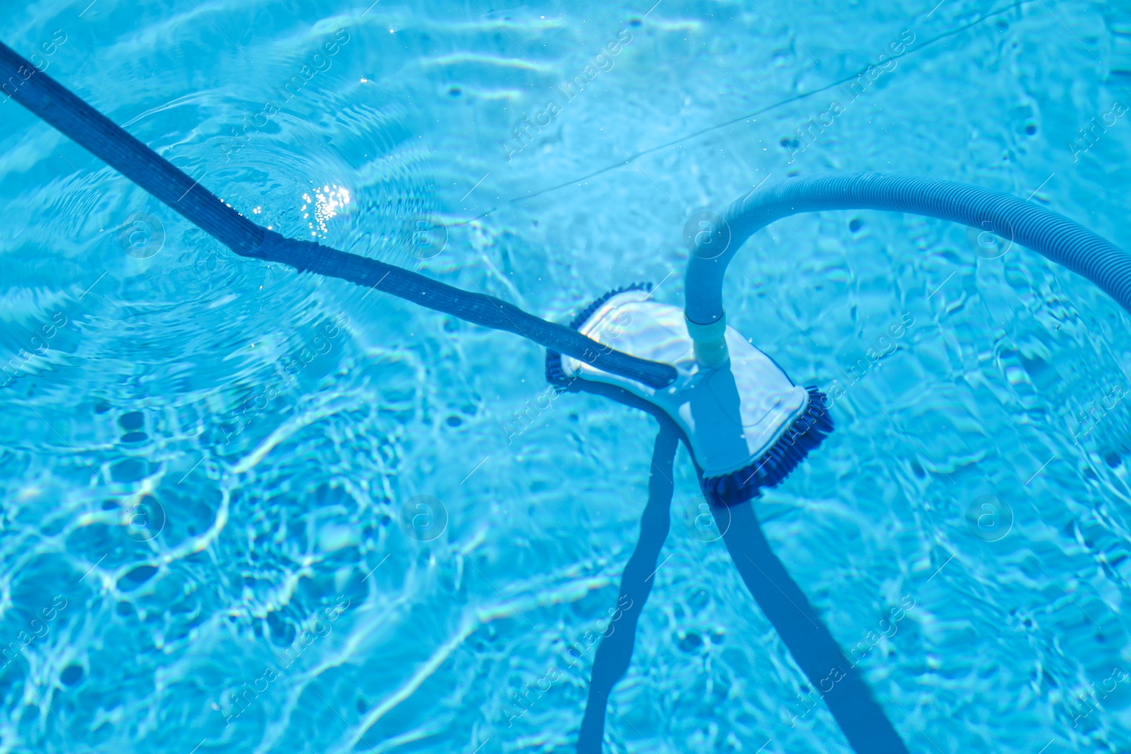 Photo of Cleaning outdoor pool with underwater vacuum, closeup