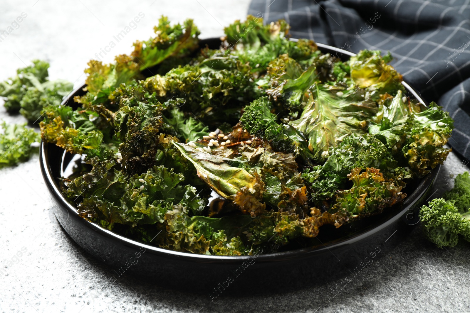 Photo of Tasty baked kale chips on grey table