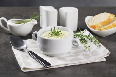 Delicious cream soup with tarragon, spices and potato in bowl served on dark textured table