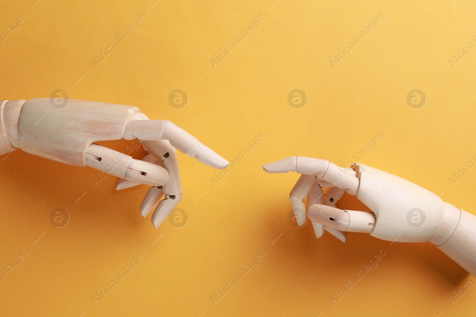 Photo of Wooden mannequin hands on orange background, flat lay