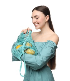 Woman with string bag of fresh lemons on white background