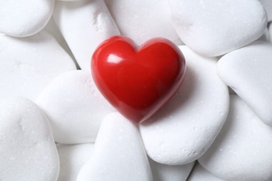 Decorative heart on white pebble stones, top view