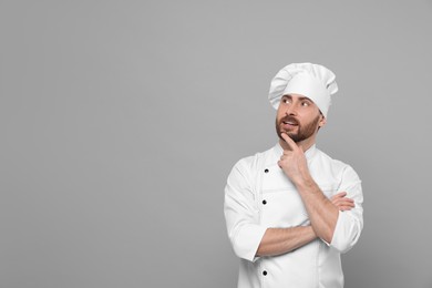 Photo of Mature chef on grey background, space for text