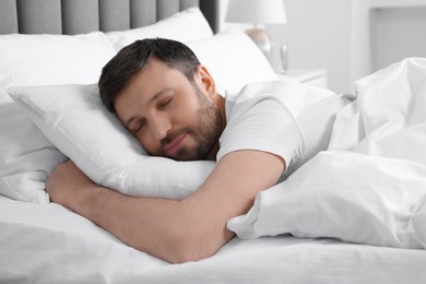 Handsome man sleeping in soft bed at home