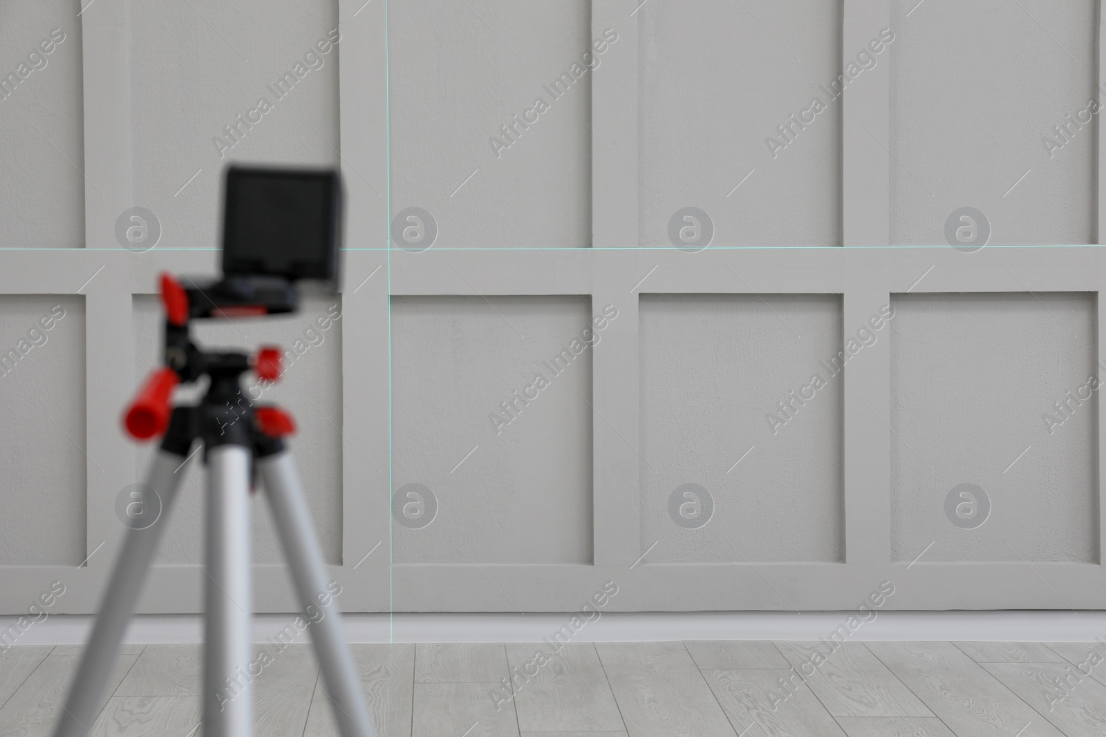 Photo of Cross lines of laser level on light wall indoors