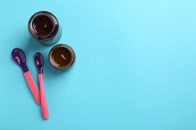 Photo of Jars with healthy baby food and spoons on light blue background, flat lay. Space for text