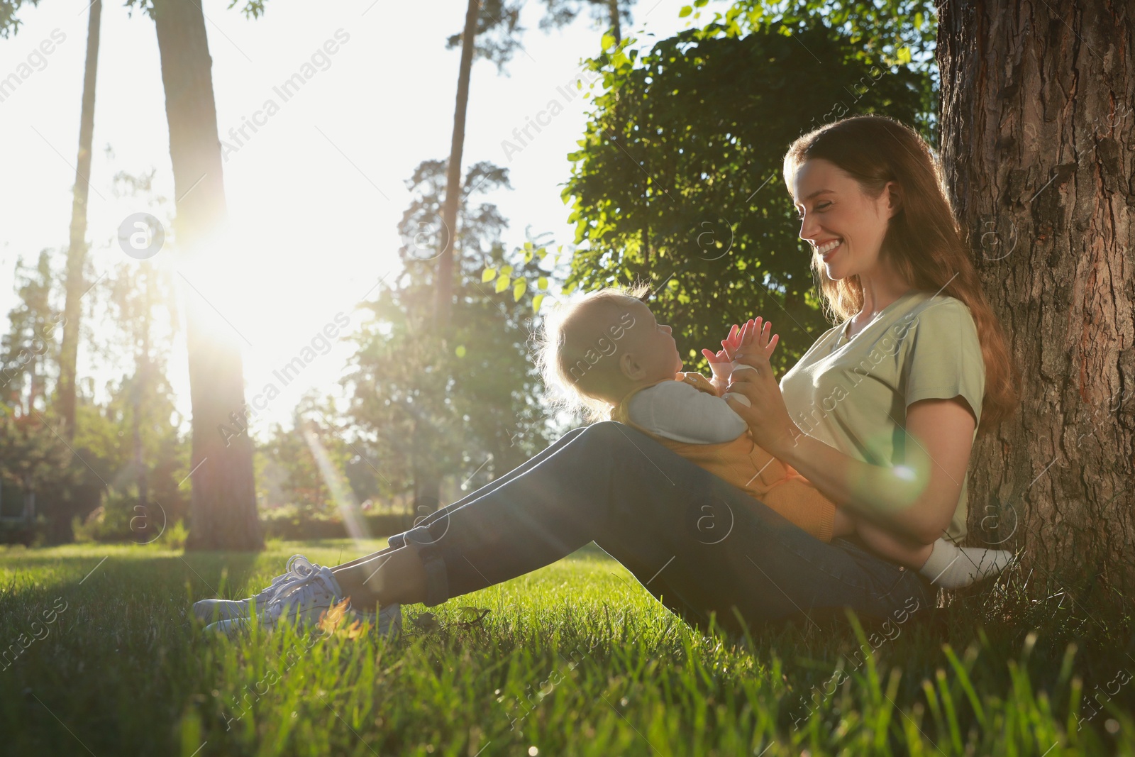 Photo of Beautiful mother with her cute daughter spending time together in park on summer day